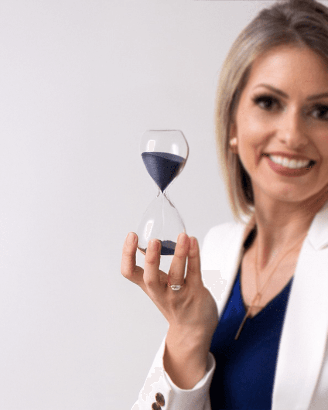 Scheila Augustin segurando uma ampulheta, simbolizando tempo e planejamento previdenciário